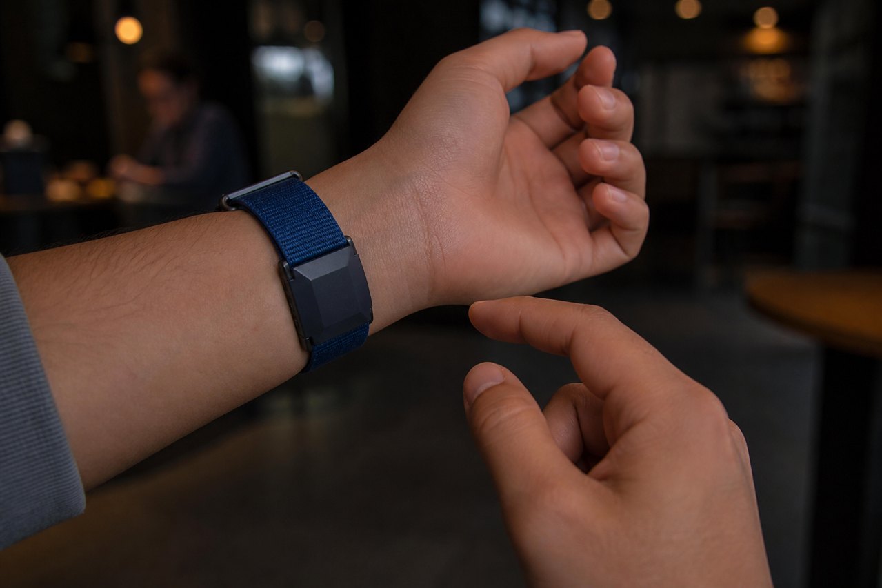 Under-wrist TapBand, finger mid-tap to approve.